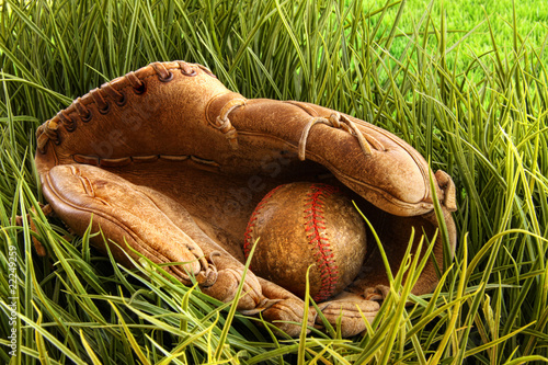 Photo: Old baseball glove with ball in the grass Old baseball glove with ball in the grass