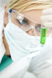 Female Scientific Researcher With Green Solution In Laboratory