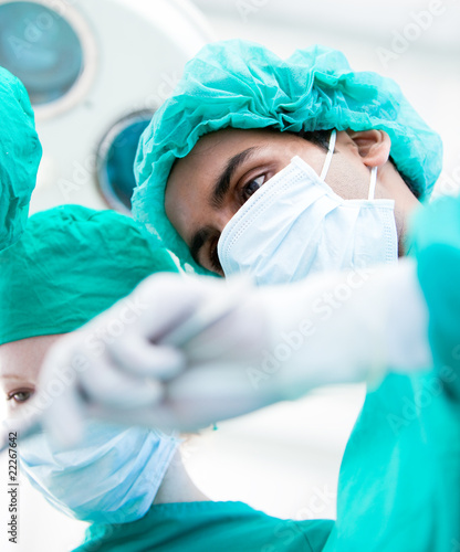Foto: Serious surgeons during an operation. Medical concept. Serious surgeons during an operation. Medical concept.