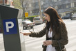 Femme payant son stationnement au parcmètre