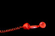 Red telephone receiver on black background