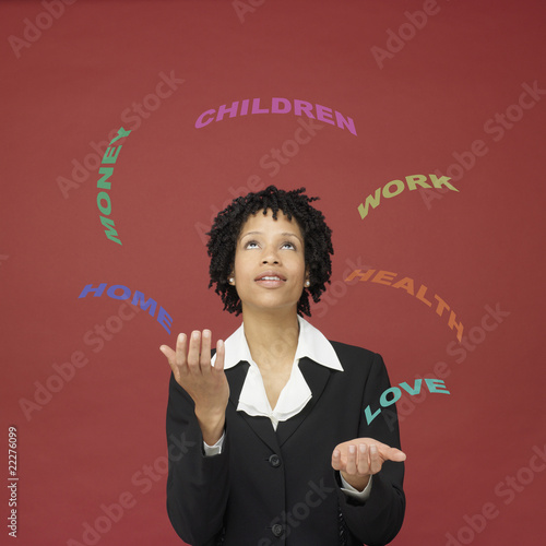 Photo: African businesswoman juggling words representing busy life African businesswoman juggling words representing busy life