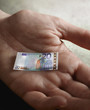 Man's hand holding tiny Euro