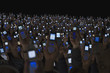 Large group of people holding open cell phones up in air