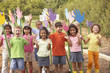 Group of children standing in garden with hand cut-out decorations