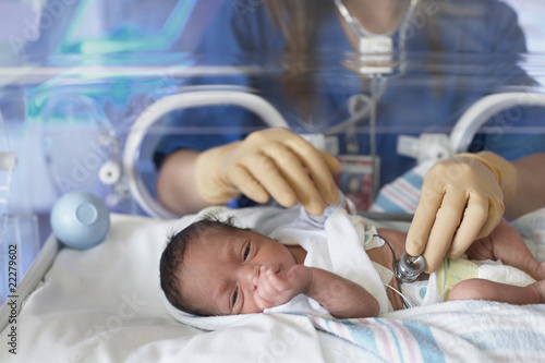 Foto: Female doctor examining newborn baby in incubator Female doctor examining newborn baby in incubator