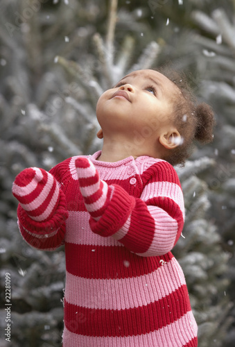 Photo: African baby girl standing in falling snow African baby girl standing in falling snow