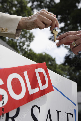 Photo: Real estate agent handing house keys to buyer Real estate agent handing house keys to buyer