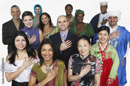 Photo: Multi-ethnic people in traditional dress holding hand on heart Multi-ethnic people in traditional dress holding hand on heart