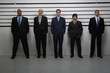 Multi-ethnic businessmen in police line up