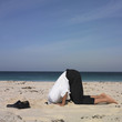 Hispanic businessman with head in sand