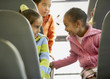 Multi-ethnic girls talking on school bus