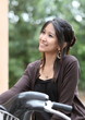 Young woman on a bicycle outdoors smiling.