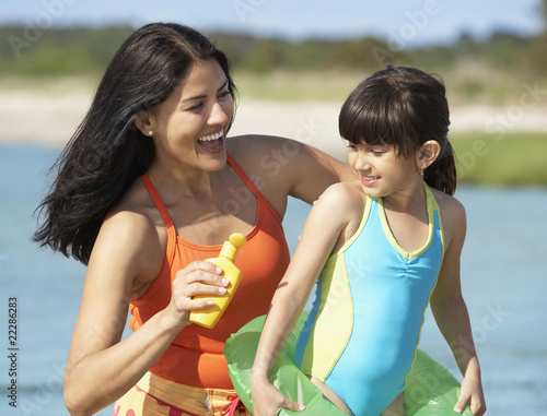 Foto: Hispanic mother applying sunscreen on daughter Hispanic mother applying sunscreen on daughter