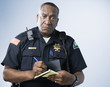 African American male police officer writing ticket