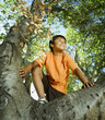 Hispanic boy climbing tree