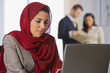 Middle Eastern businesswoman looking at laptop