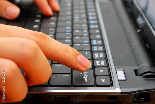 Photo: Finger pressing backspace button on laptop Finger pressing backspace button on laptop