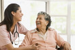 Senior Hispanic woman and nurse laughing