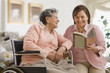 Hispanic woman reading to mother