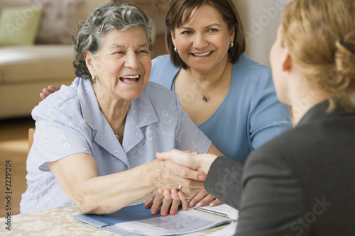 Photo: Senior Hispanic woman shaking hands with businesswoman Senior Hispanic woman shaking hands with businesswoman