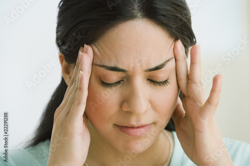 Photo: Hispanic woman rubbing forehead Hispanic woman rubbing forehead