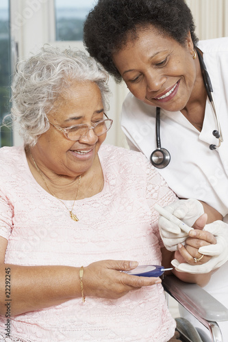 Photo: Doctor testing African American woman's blood sugar Doctor testing African American woman's blood sugar