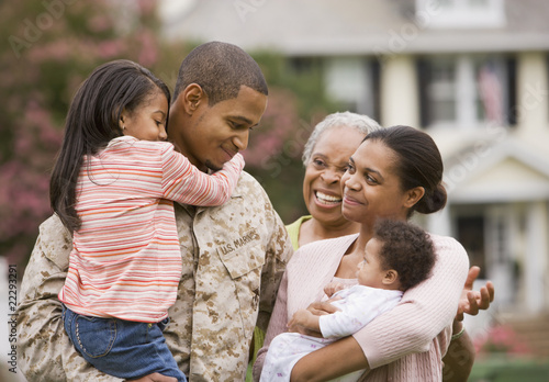 Photo: African American military father hugging family African American military father hugging family