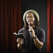 African man reading into microphone