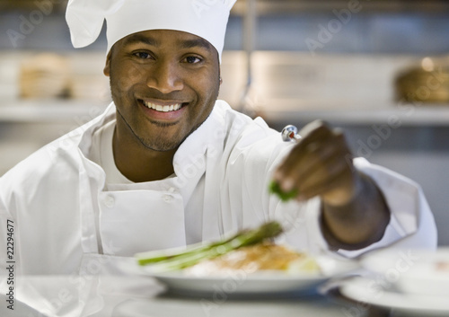 Photo: African male chef garnishing plate of food African male chef garnishing plate of food