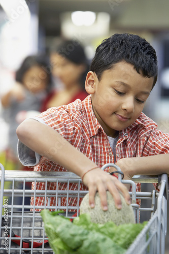 Photo: Indian boy putting fruit in shopping cart Indian boy putting fruit in shopping cart