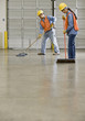 Multi-ethnic warehouse workers sweeping floor