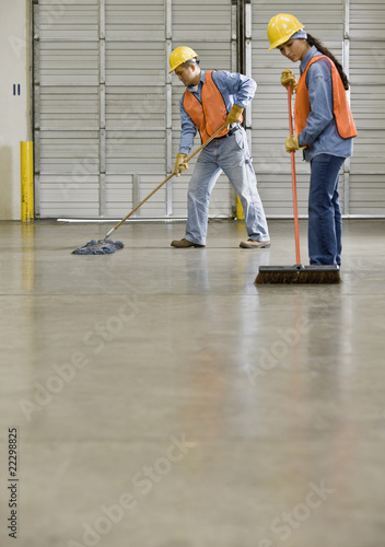Foto: Multi-ethnic warehouse workers sweeping floor Multi-ethnic warehouse workers sweeping floor