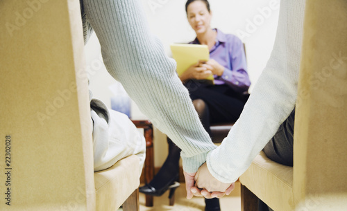Photo: Multi-ethnic couple holding hands at therapy session Multi-ethnic couple holding hands at therapy session