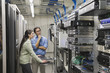 Multi-ethnic coworkers working in computer server room