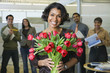 African businesswoman holding bouquet of flowers