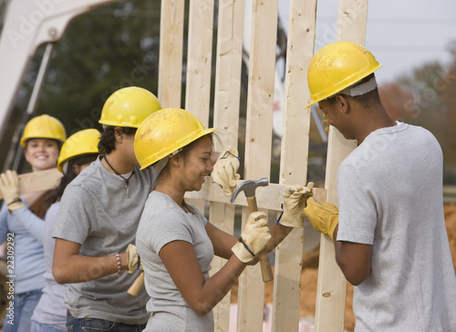 Photo: Volunteers wearing hard-hats working at construction site Volunteers wearing hard-hats working at construction site