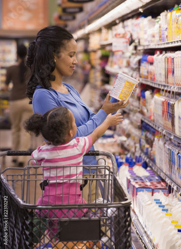 Photo: Mixed race woman shopping with daughter in grocery store Mixed race woman shopping with daughter in grocery store