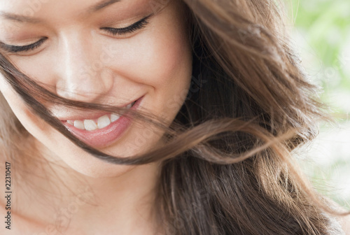 Photo: Mixed race woman looking down and smiling Mixed race woman looking down and smiling