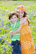 Two Children Hugging in a Field of Flowers