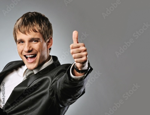 Photo: Happy businessman showing his thumb up with smile . Happy businessman showing his thumb up with smile .