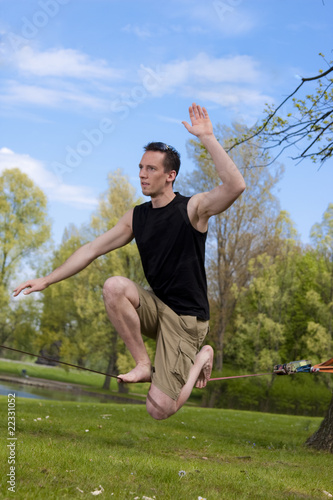 Foto: Mann hockt auf Slackline Mann hockt auf Slackline