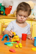 Little child playing plasticine