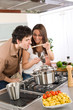 Couple cook in kitchen - man taste food Couple cook in kitchen - man taste food