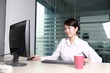 Photo: young asian businesswoman working with computer in office young asian businesswoman working with computer in office
