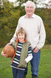 Photo: Grandfather With Grandson Holding Football Outside Grandfather With Grandson Holding Football Outside