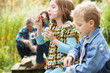 Photo: Two Young Children Blowing Bubbles On Countryside Picnic Two Young Children Blowing Bubbles On Countryside Picnic