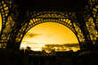 Orange sunset under Eiffel Tower arches