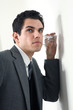 junger business mann hört an einer wand mit glas