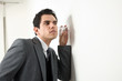 Foto: junger business mann hört an einer wand mit glas junger business mann hört an einer wand mit glas